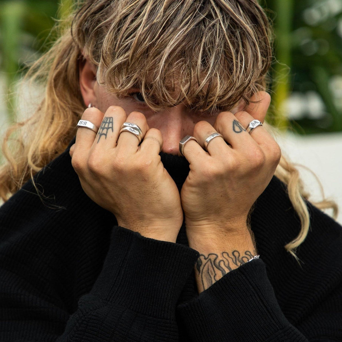 A lifestyle shot of a model with long blonde hair wearing multiple Billie Jo rings, including the ROSA I RING.