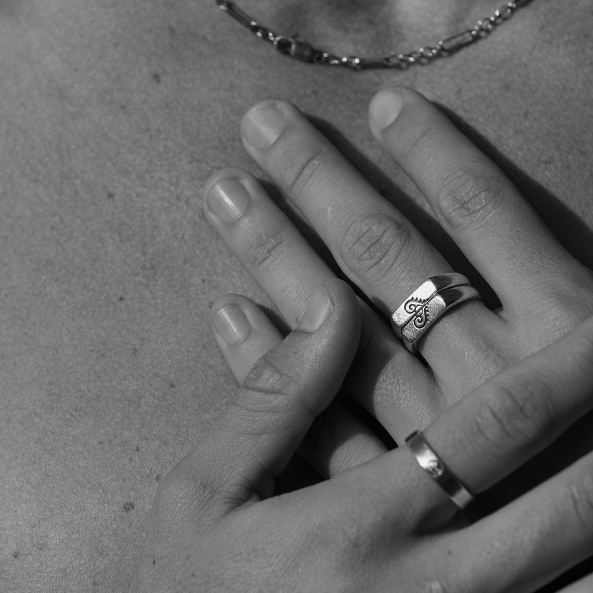 A man's hands with the Billie Jo Connection Stackers rings, in a black and white editorial shot. Australian men's jewellery.