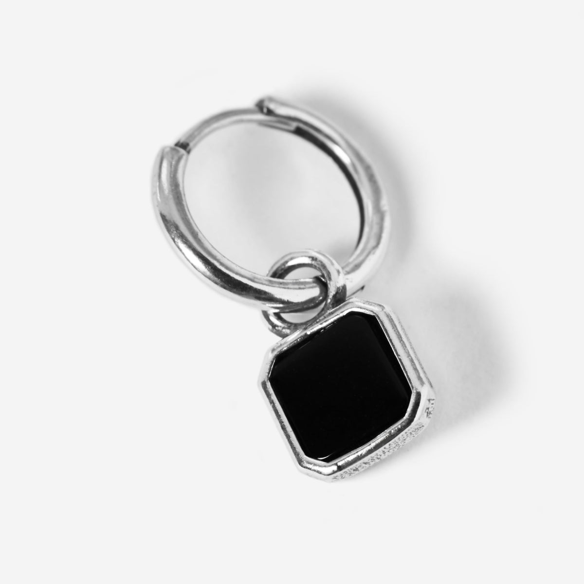 A single sterling silver Nox Earring from Billie Jo, showcasing the huggie hoop and the faceted black stone pendant in a detailed product shot.