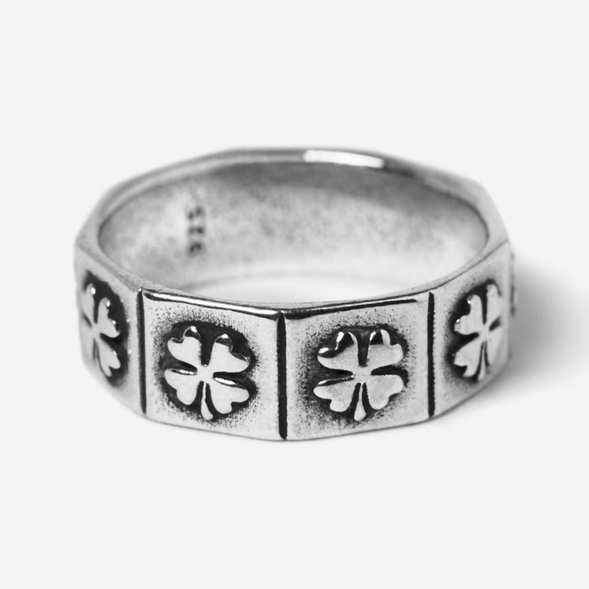 A studio shot of the Billie Jo LUCKY RING. This men's sterling silver ring has a unique geometric band with an embossed four-leaf clover pattern.