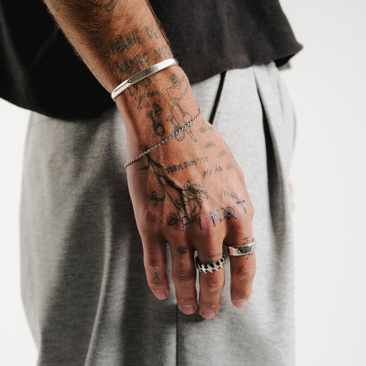 A close-up of the Billie Jo Surge Ring on a tattooed hand, showing the detailed craftsmanship of this sterling silver men's jewellery piece.