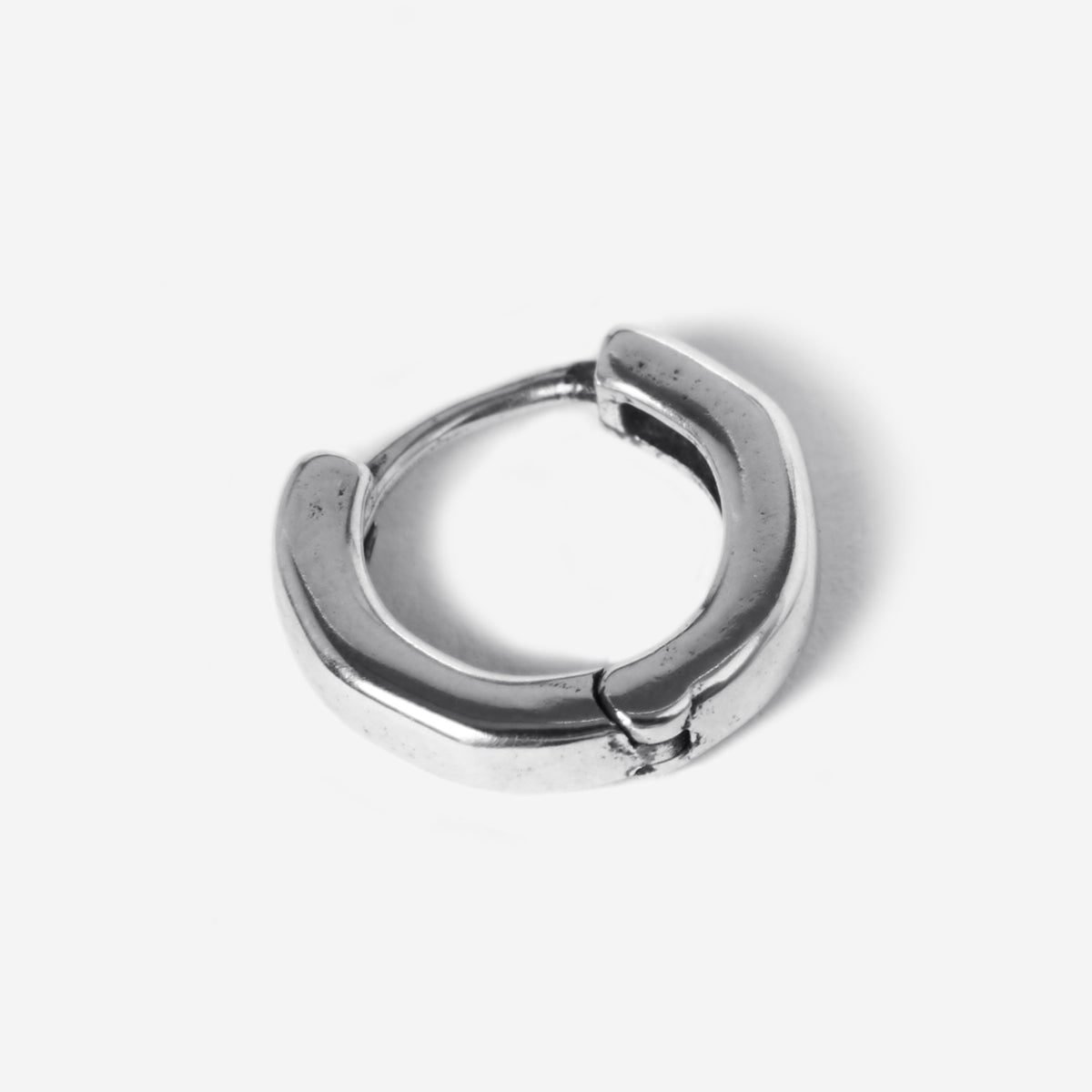 A detailed product shot of a single Billie Jo Lumina hoop earring in sterling silver, highlighting its classic, chunky design and secure clasp.