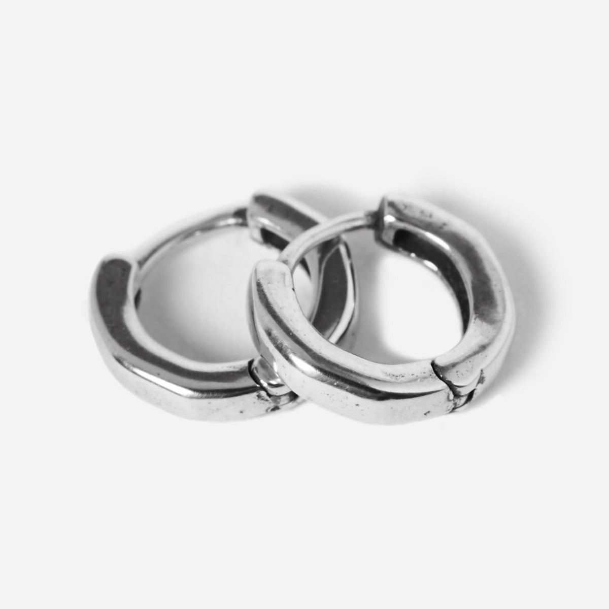 A pair of sterling silver Billie Jo Lumina hoop earrings, with a classic rounded shape and secure hinged clasp, shot on a clean white background.