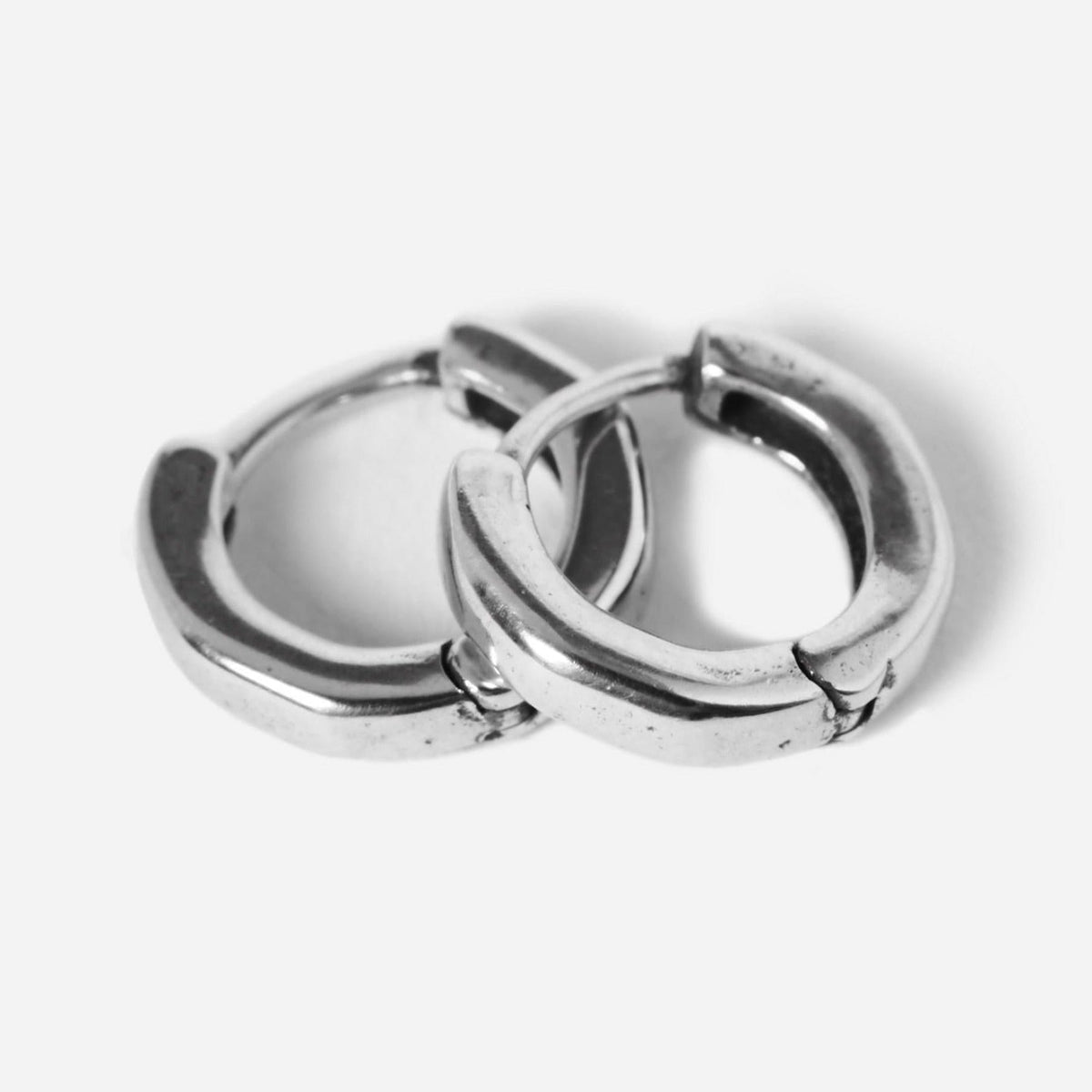 A pair of sterling silver Billie Jo Lumina hoop earrings, with a classic rounded shape and secure hinged clasp, shot on a clean white background.
