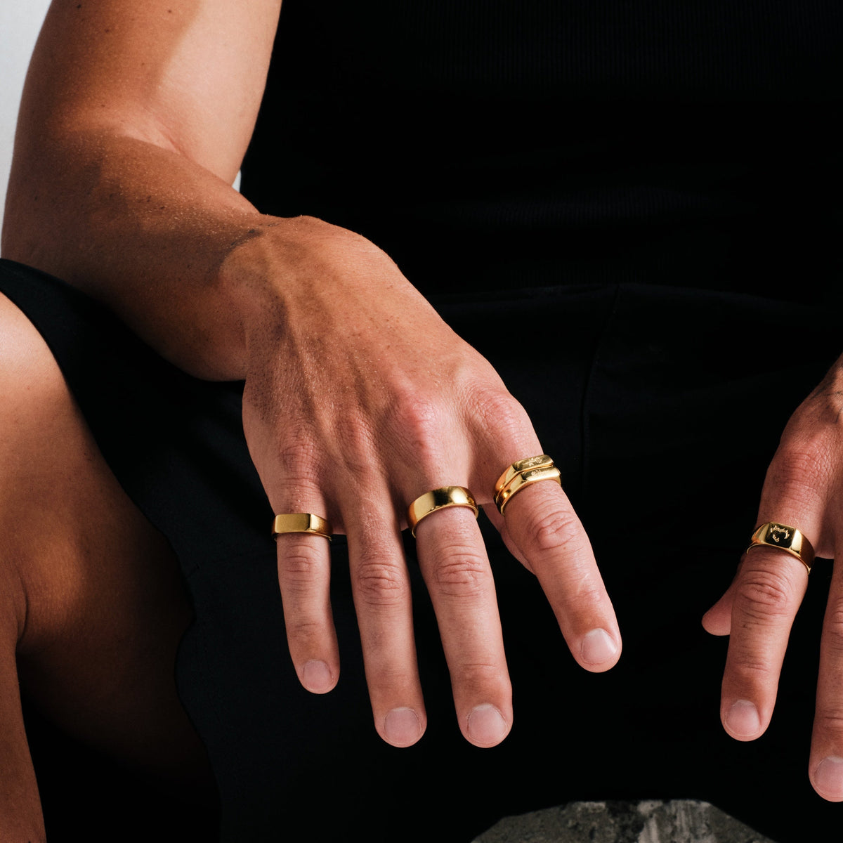 Men's Gold Canvas Ring in 18k gold infused stainless steel, worn on his right middle finger, black singlet, black pants