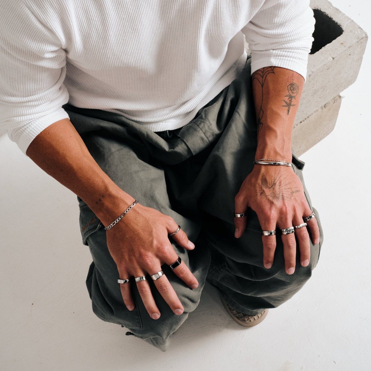 Men's Drifter Cuff in 316L stainless steel, silver finish, worn on his left wrist, white waffle long sleeve, olive pants