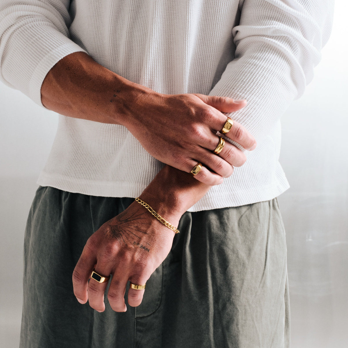 Men's Gold Revival Ring in 18k gold infused stainless steel, worn on the ring finger, right hand over left forearm