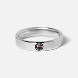 A different angle of the sterling silver Reflection Ring by Billie Jo, showcasing the detailed smiley face engraving with red 'X' eyes on the band.
