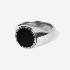 Billie Jo's Abyss Ring in sterling silver, featuring a round black onyx stone with a detailed bezel setting. A modern men's signet ring with a textured finish.