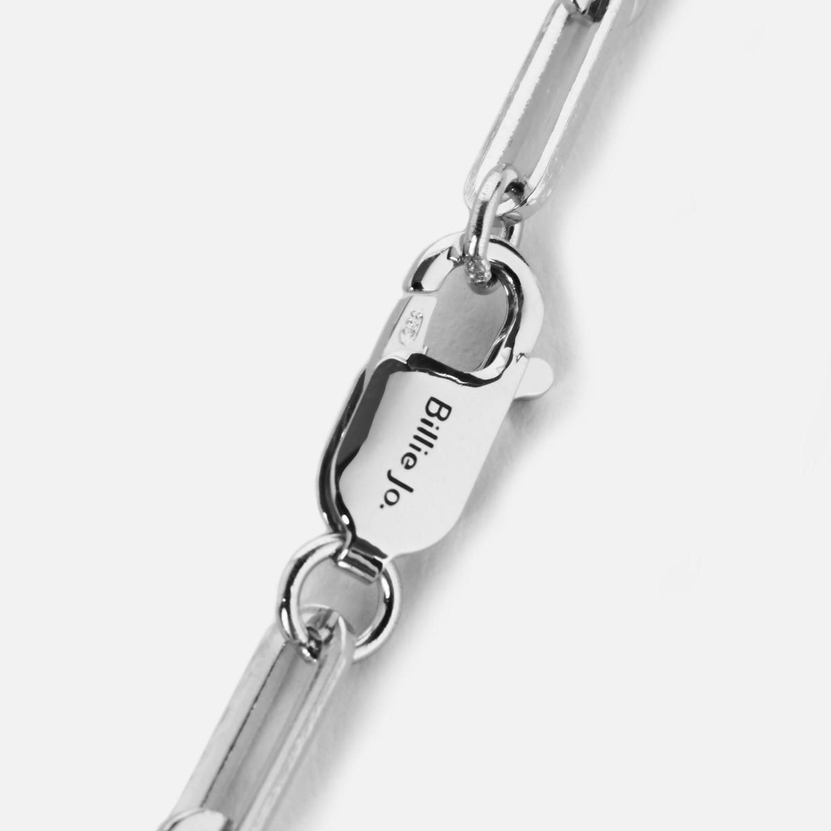 Close-up detail shot of the Billie Jo Link Bracelet clasp, showcasing the engraved brand name. The sterling silver jewellery piece has a high-shine, polished finish, reflecting the modern and masculine aesthetic of the Australian brand.