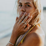 A detailed shot of the Billie Jo Solace Ring worn on the index finger, showing the engraved flower design and the ring's textured sterling silver band.