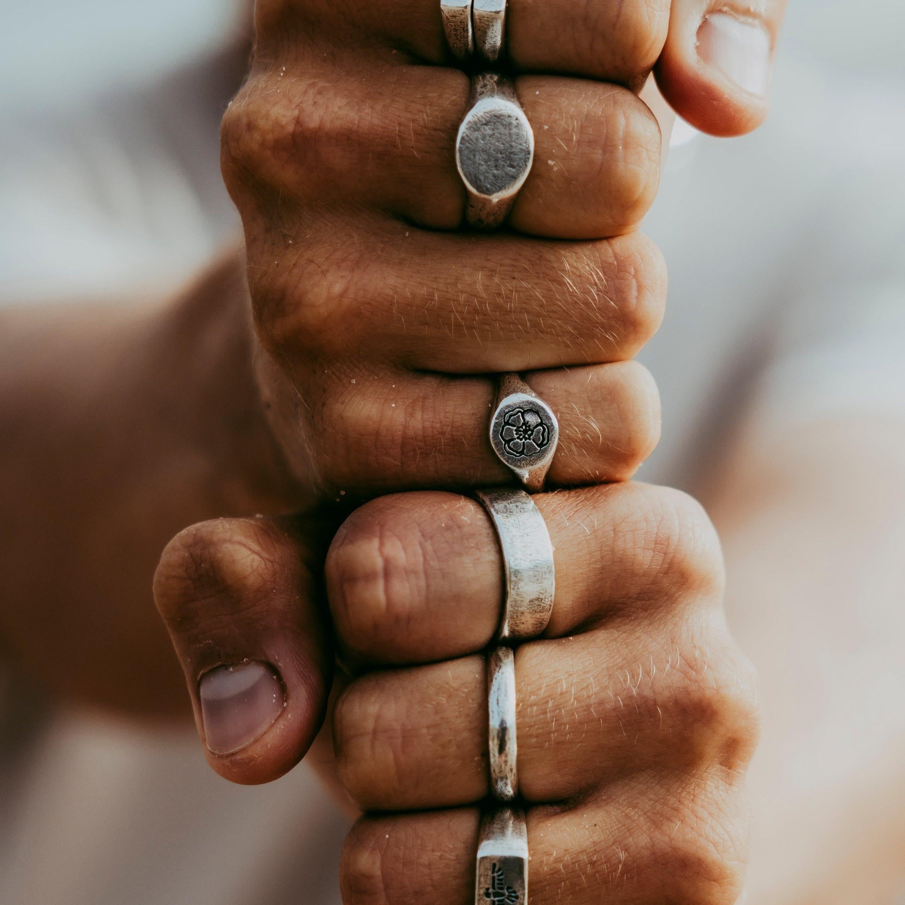 Lifestyle image of a man wearing the Solace Ring and other silver jewellery from Billie Jo, with a focus on the hand and ring details.