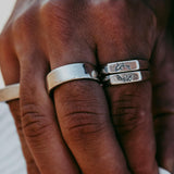 A close-up lifestyle shot of a man's hand wearing the sterling silver Billie Jo Canvas Ring stacked with other rings, showing its everyday style.