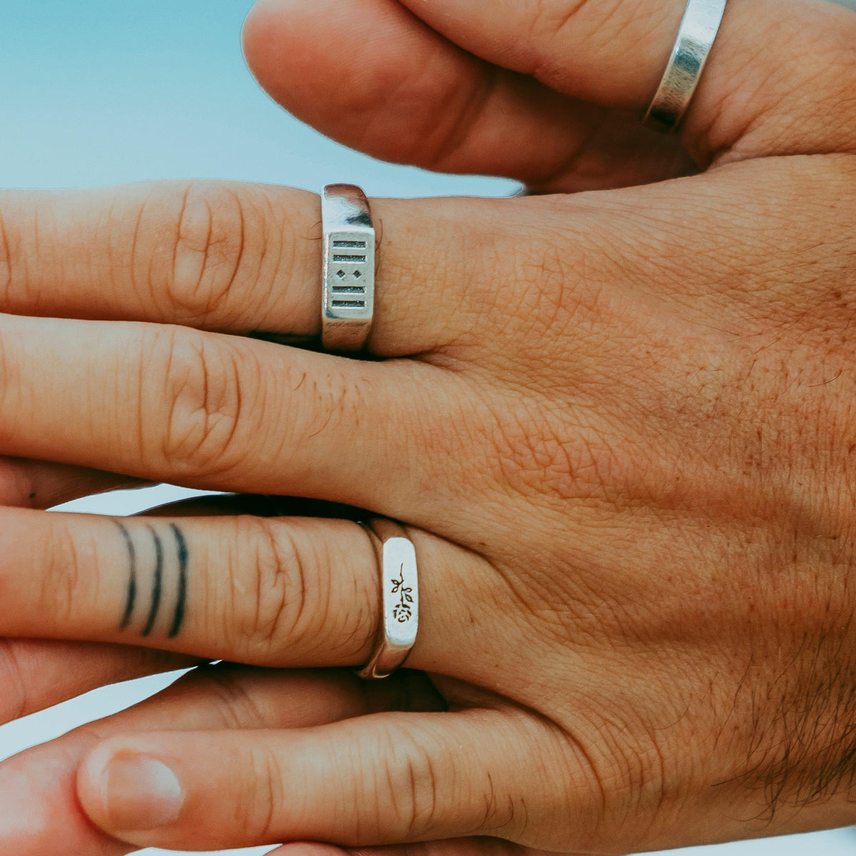 A close-up on-hand shot of a model wearing the sterling silver Billie Jo ROSA I RING, showing how it sits on the finger.