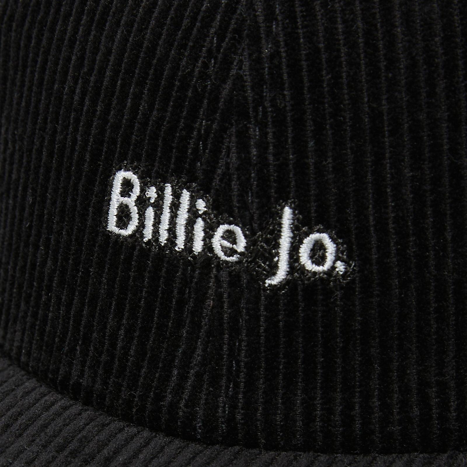 A close-up detail shot of the white embroidered 'Billie Jo' logo on the black corduroy fabric of the Corduroy Hat. Australian men's jewellery brand.