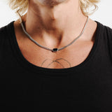 A man wearing the sterling silver Eclipse Necklace from Billie Jo, styled with a black tank top to showcase the black onyx stone.