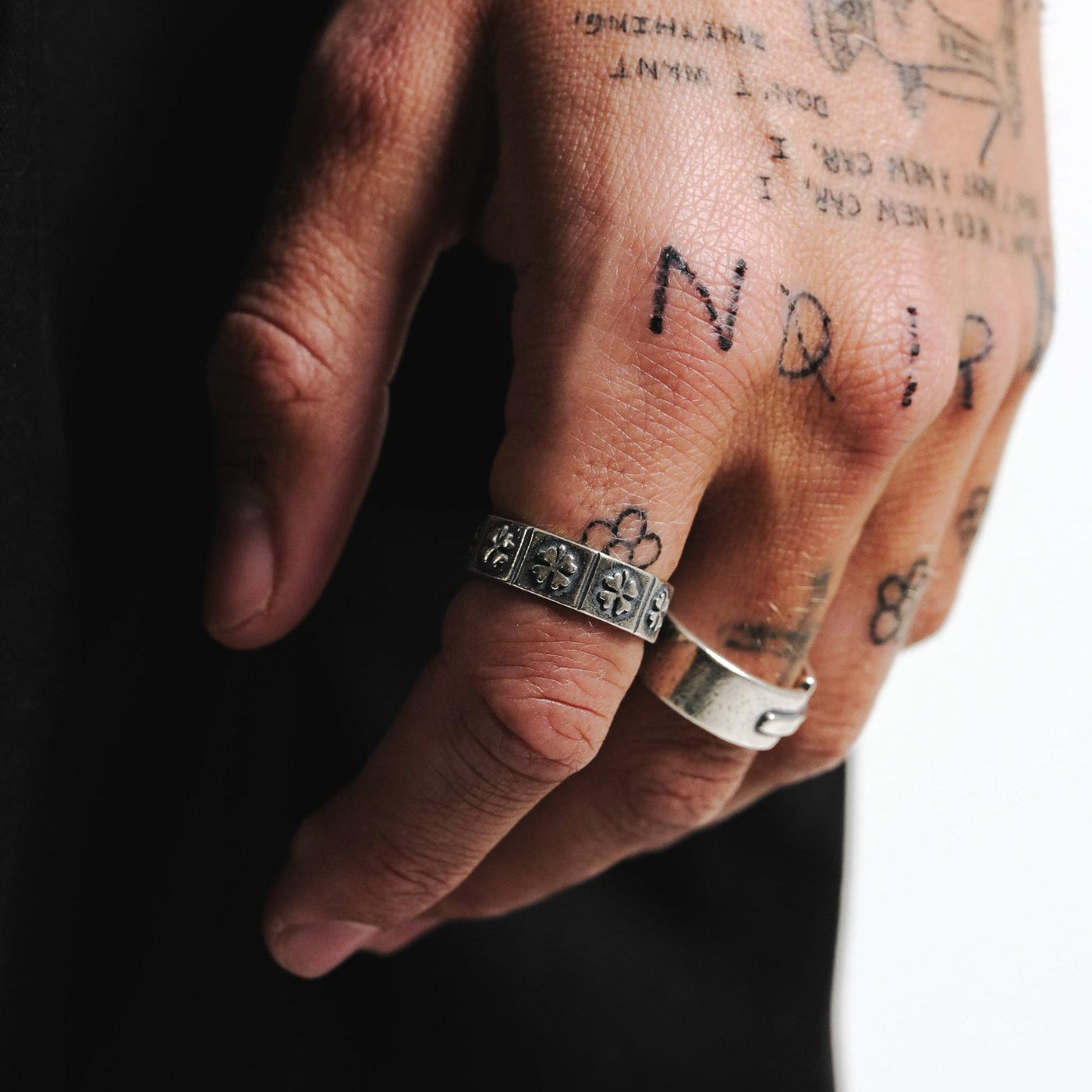 A close-up of the Billie Jo LUCKY RING on a man's hand, showing the detailed clover engravings and the ring's solid sterling silver construction.