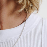 Side view of a man with blonde hair wearing the Slim Batch Necklace, showing how the sterling silver chain sits elegantly on the collarbone.
