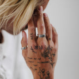 A model with blonde hair wears the Elaris Ring by Billie Jo, showing off the butterfly detail. An on-trend piece of men's jewellery from Australia.
