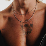 A detailed close-up of the sterling silver Slim Link Necklace from Billie Jo, resting on a man's chest with a tattoo visible underneath.