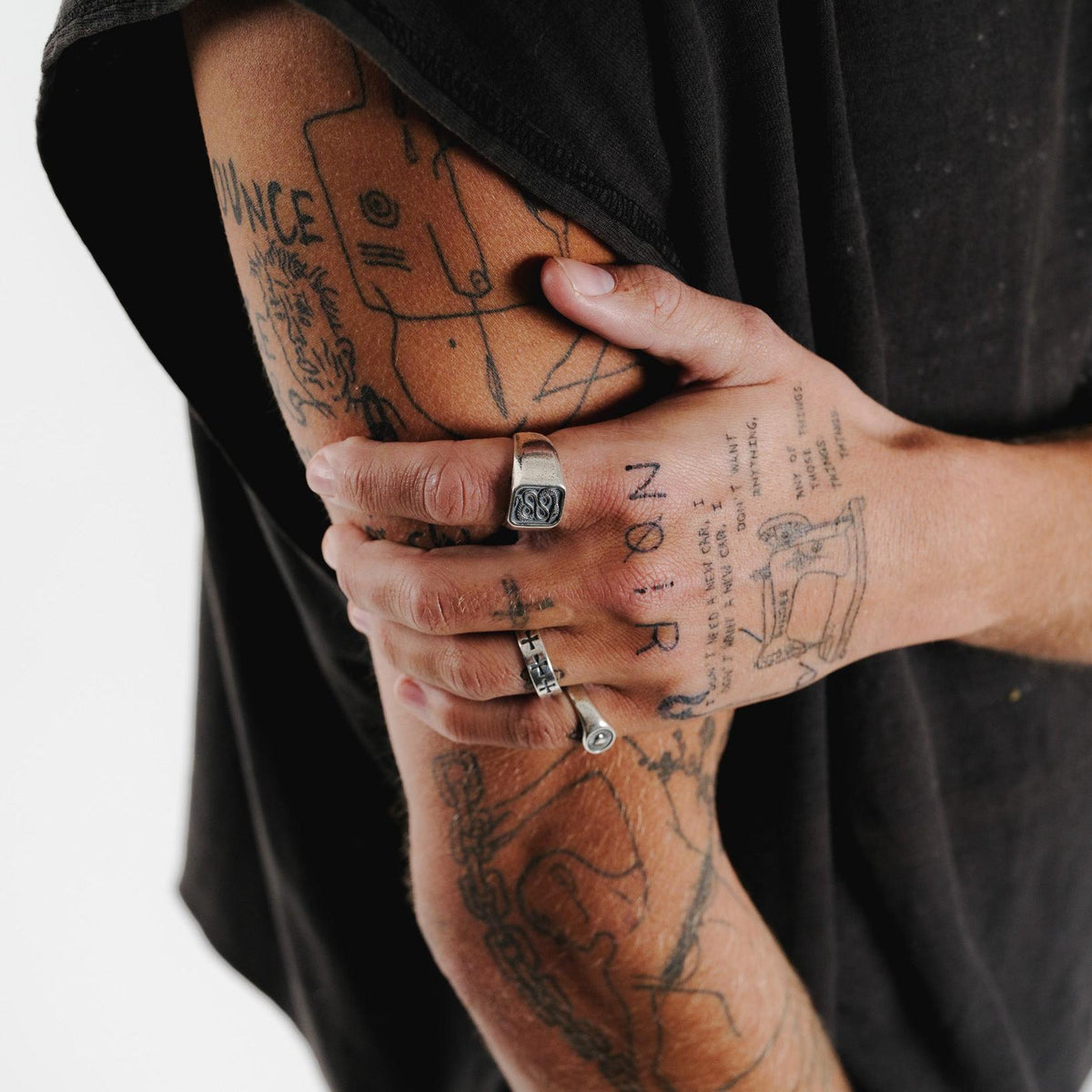 A final look at the Billie Jo Serpent Ring, styled on a tattooed model's hand, showcasing its versatility and modern aesthetic for men's jewellery.