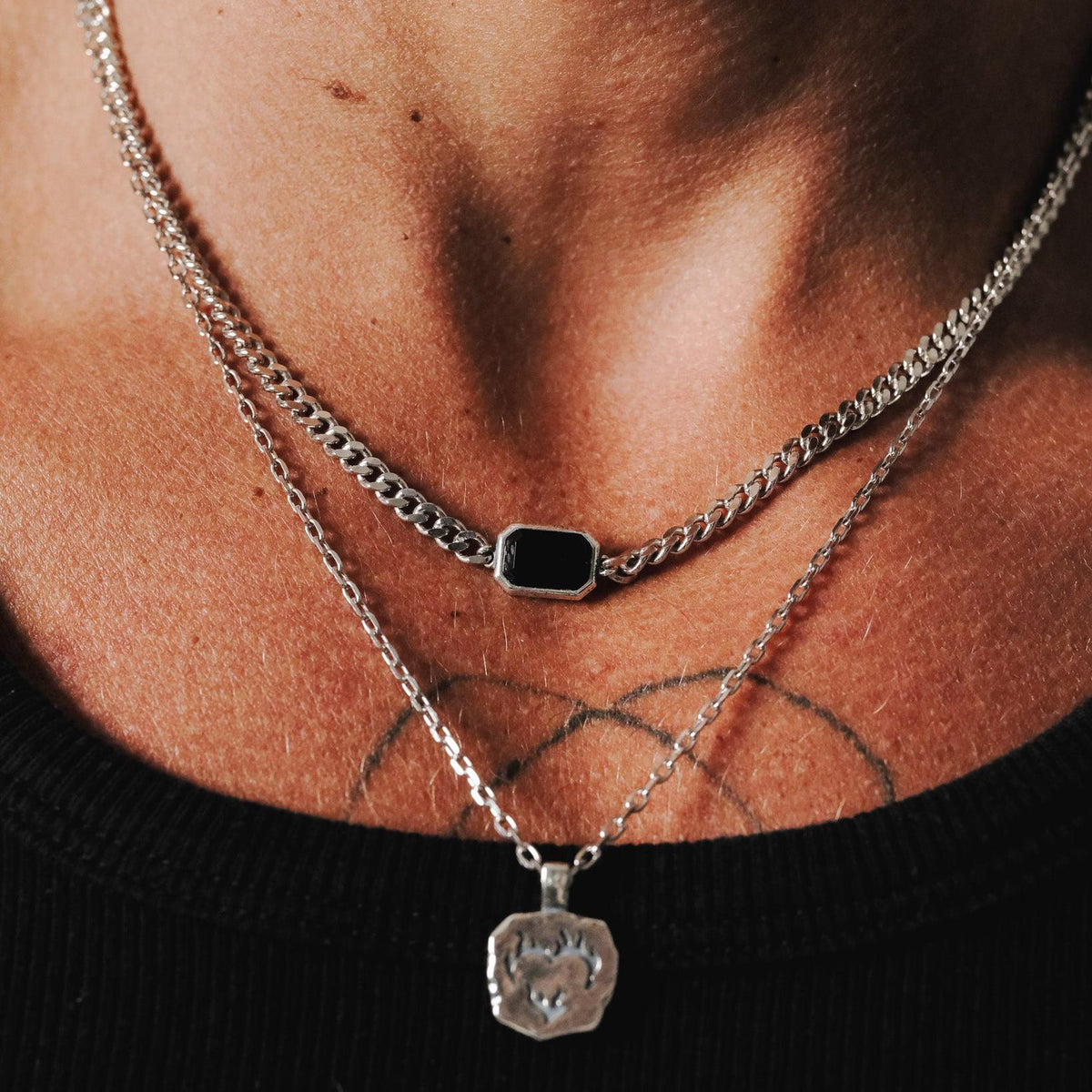 Close-up of the sterling silver Eclipse Necklace from Australian brand Billie Jo, layered with another silver pendant necklace for a stacked look.