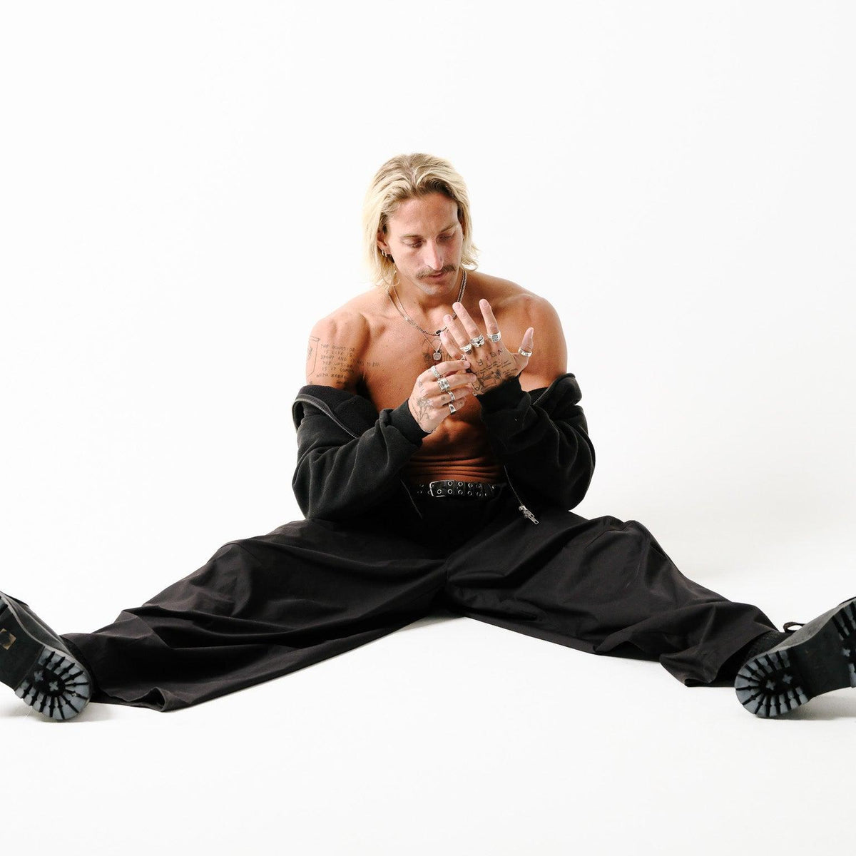A male model wearing the Billie Jo Eclipse Necklace and multiple silver rings, in a full-body shot showcasing the brand's modern aesthetic.