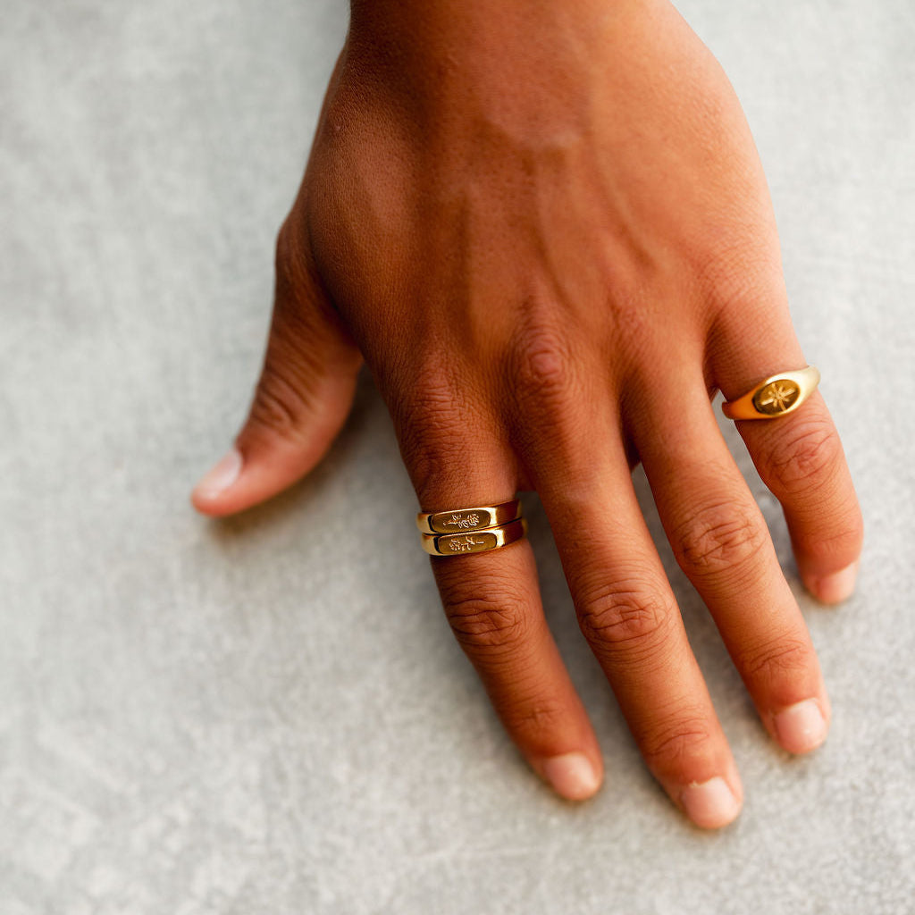 A close-up of the Billie Jo Rosa Stacker rings in 18k gold vermeil, worn on a man's hand, showing the detailed rose engraving and polished finish.