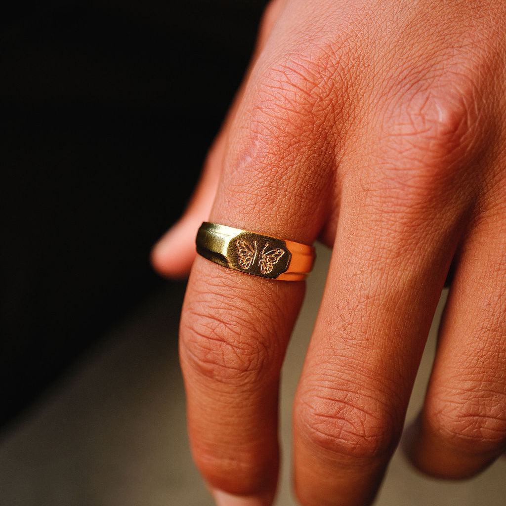 The 18k gold vermeil Revival Ring by Billie Jo, held in hand to display its size and scale. The image captures the quality craftsmanship of this Australian-designed men's ring.