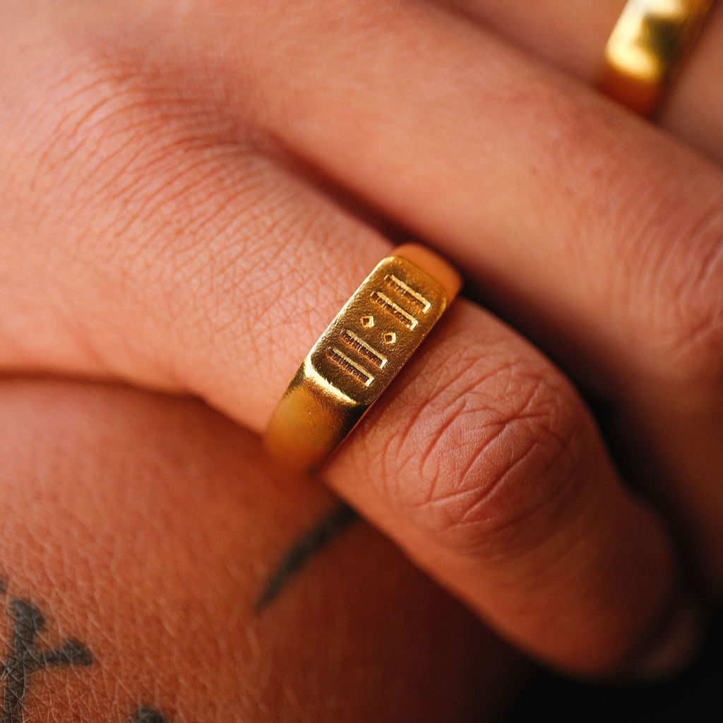 A close-up of a man wearing the Billie Jo Momento Ring in gold, highlighting the engraved '11:11' detail. Modern men's jewellery from Australia.