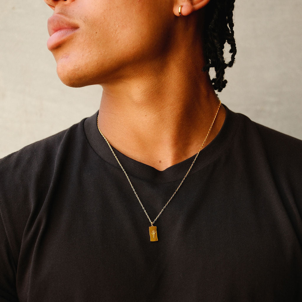 A man wearing the gold Lumina Earring from Billie Jo, shown in a stylish editorial shot that captures the brand's modern and masculine aesthetic.