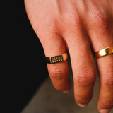 A close-up of the Billie Jo Momento Ring in gold, worn on a man's finger against a dark background, highlighting the '00:00' engraving. Modern Australian men's jewellery.