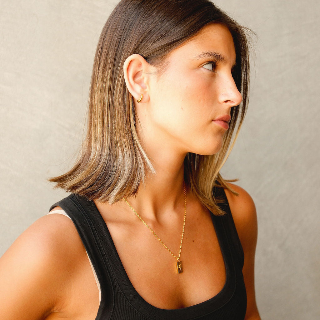 A woman with shoulder-length hair wearing the 18k gold vermeil Lumina Earring from Australian jewellery brand Billie Jo, showcasing its subtle elegance.