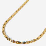 Gold chain necklace on a light gray background