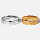 Two rings, one silver and one gold, on a white background