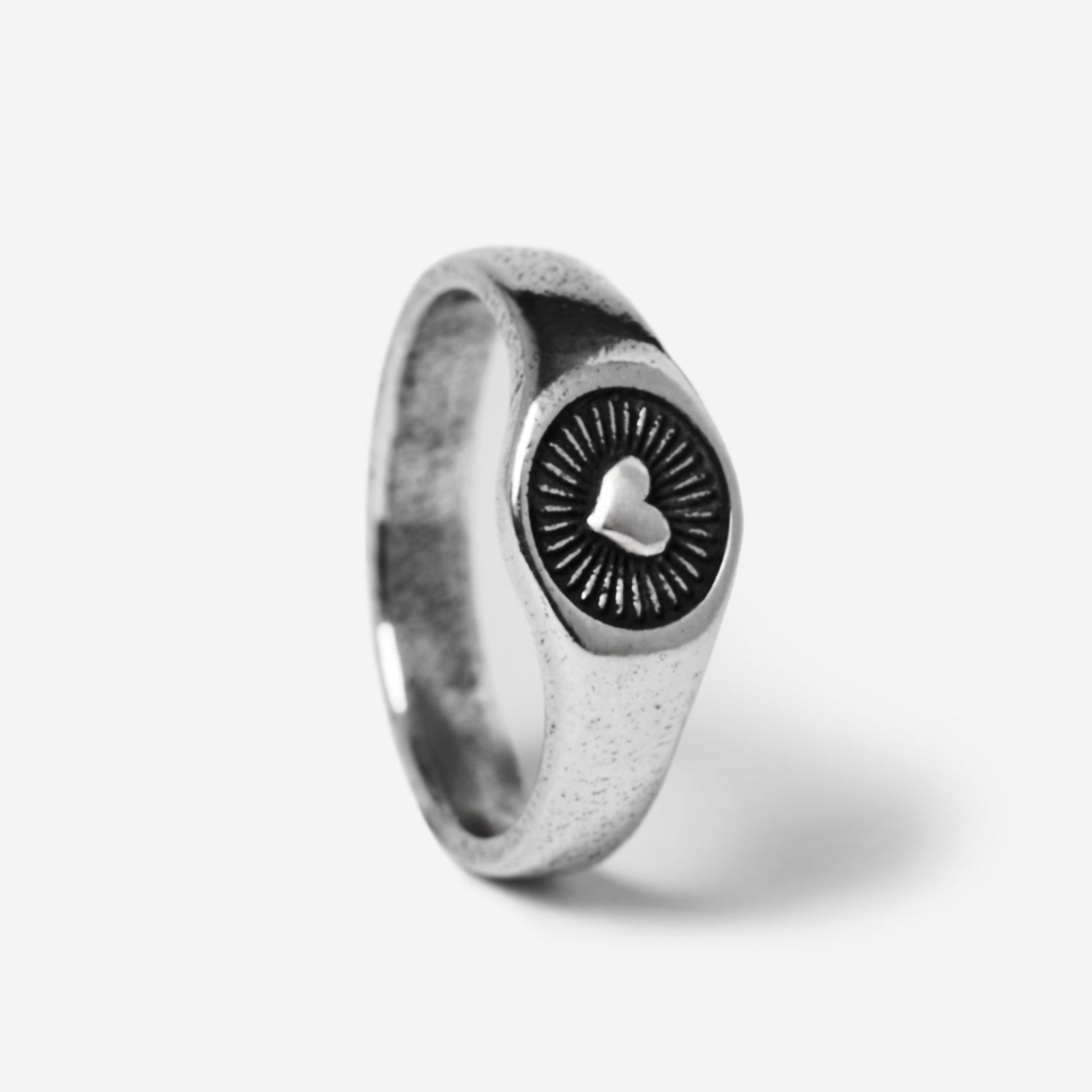A standing, angled product shot of the sterling silver Vita Ring. This image provides a clear view of the ring's unique heart and sunburst design, a signature piece from Billie Jo men's jewellery.