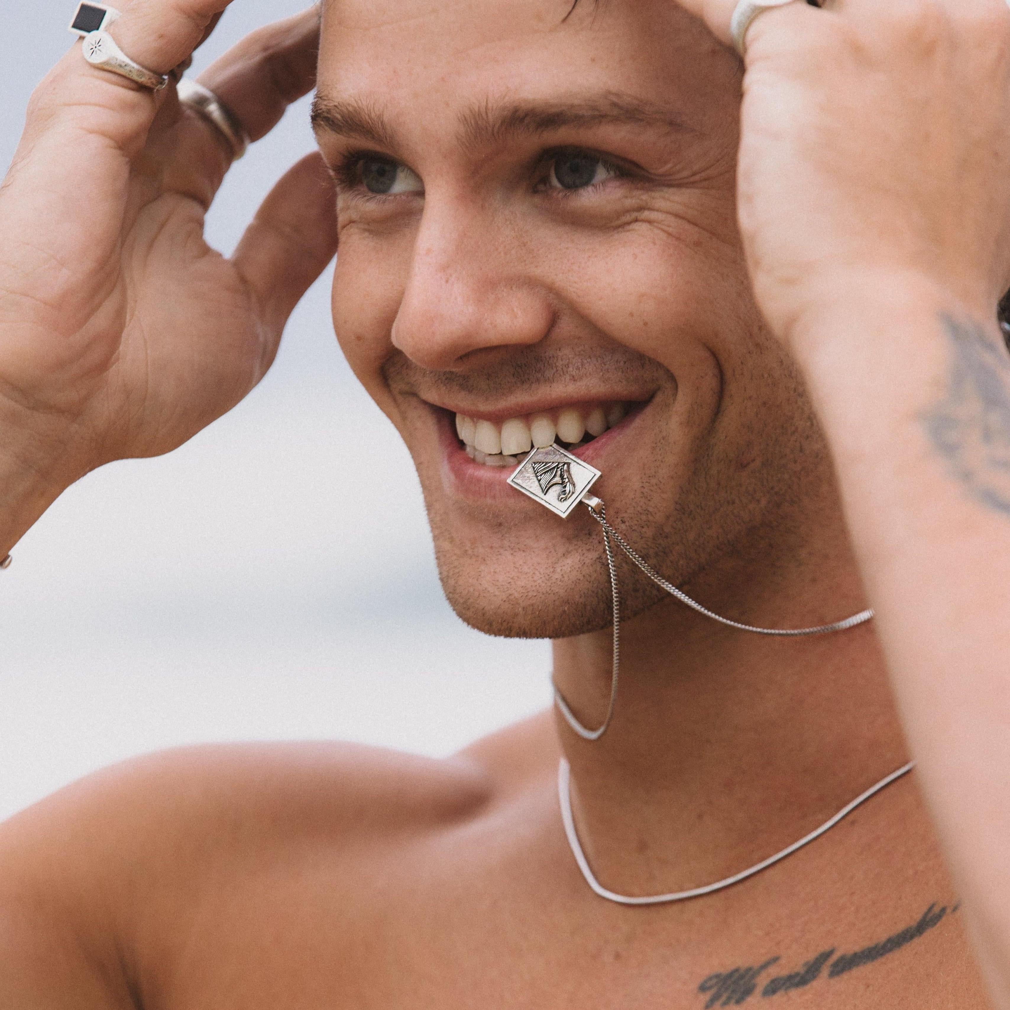The sterling silver Burleigh Pendant by Billie Jo, styled in a flat lay on a textured, neutral-coloured surface to showcase its design.