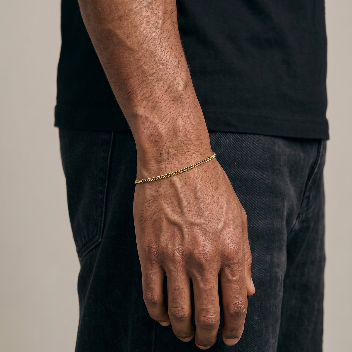 Gold stainless steel curb bracelet on mans wrist