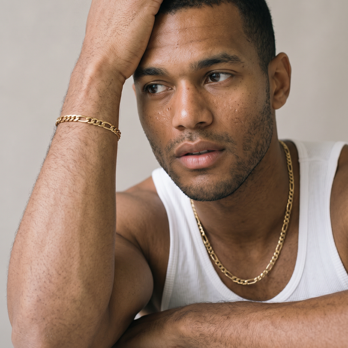 A gold stainless steel slim Figaro chain necklace from Australian jewellery brand Billie Jo, worn by a male model, a waterproof sweat proof everyday necklace and the perfect gift for him.