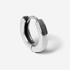 A single sterling silver Billie Jo Lumina hoop earring, showcasing its smooth, polished finish and minimalist design against a stark white background.