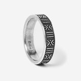 A close-up, angled product shot of the sterling silver Relic Ring by Billie Jo, showcasing its oxidised, engraved pattern of lines and symbols.