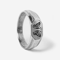 A studio shot of the sterling silver Revival Ring by Billie Jo. The ring has a flat, elongated face with two butterfly engravings and a textured, rustic finish.