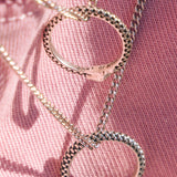 Close-up of two Billie Jo Ouroboros Pendants, showing the detailed snake scale texture and the engraved brand logo on the sterling silver surface.