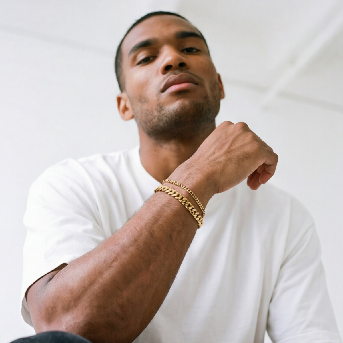 A man wearing a gold stainless steel bracelet layered - from Australian jewellery brand Billie Jo, styled for everyday casual wear.