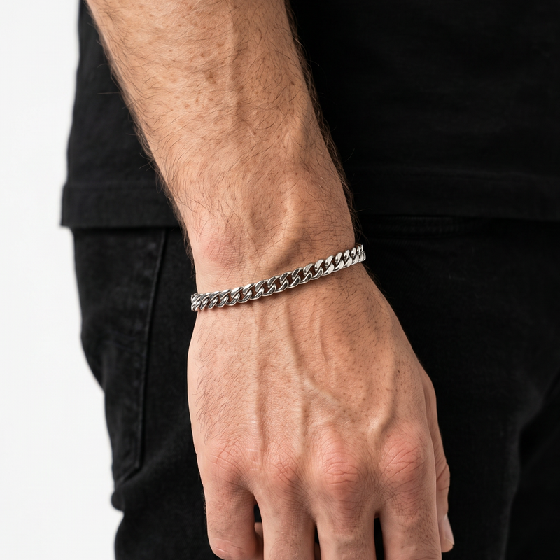 A male model wearing a silver stainless steel slim Figaro chain necklace from Australian jewellery brand Billie Jo, shot against a sleek silver chrome background. 