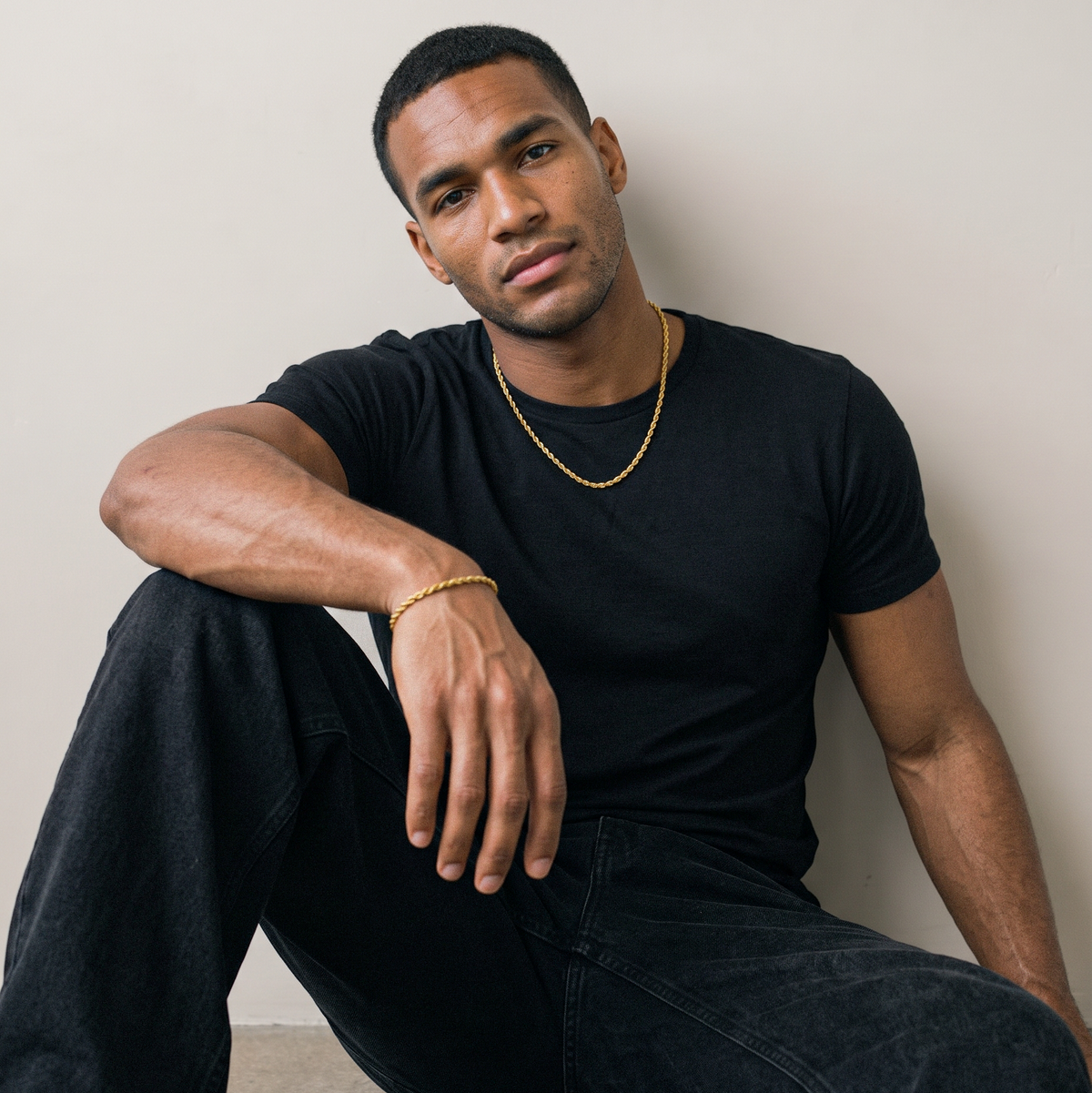 A gold tone stainless steel slim rope chain set from Australian jewellery brand Billie Jo, worn by a male model against a warm gold backdrop, a waterproof sweat proof everyday necklace and the perfect gift for him.