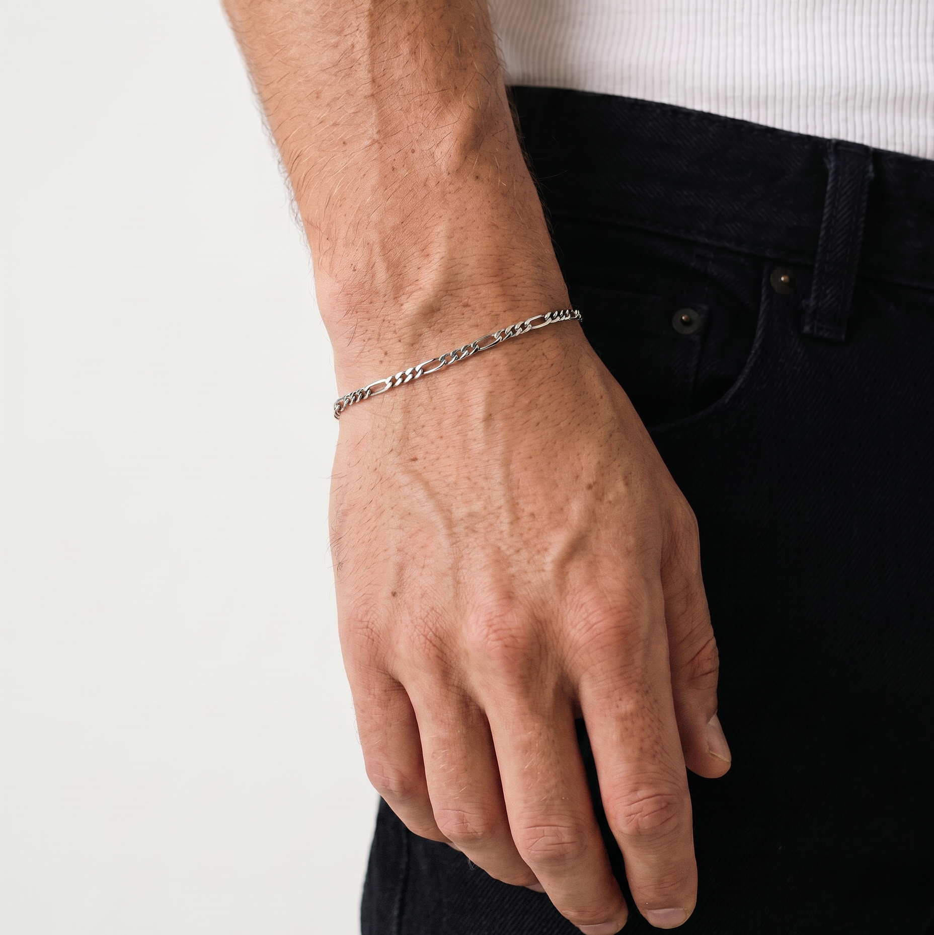 A close up of a silver stainless steel men's Figaro chain bracelet from Australian jewellery brand Billie Jo, worn against skin showing waterproof everyday style.