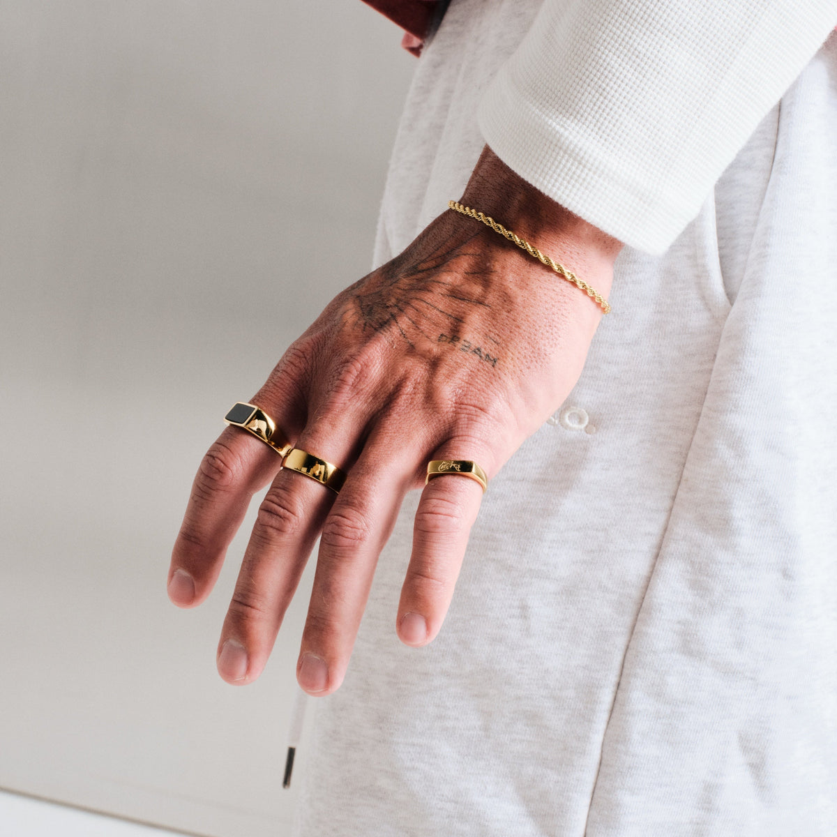 Men's Gold Canvas Ring in 18k gold infused stainless steel, worn on the middle finger, hand hanging by his side
