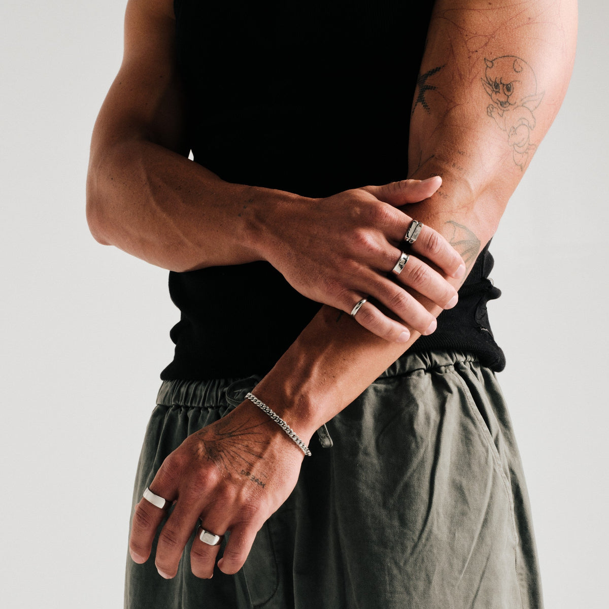 Men's Canvas Ring in 316L stainless steel, silver finish, worn on his left index finger, arms crossed in front