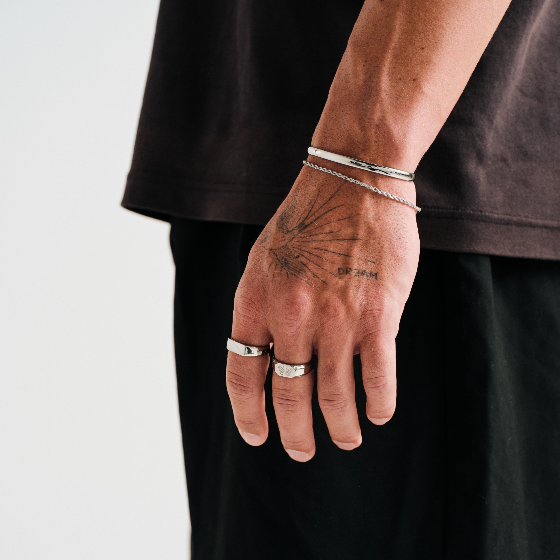 Men's Drifter Cuff in 316L stainless steel, silver finish, worn on his left wrist, hand hanging by his side